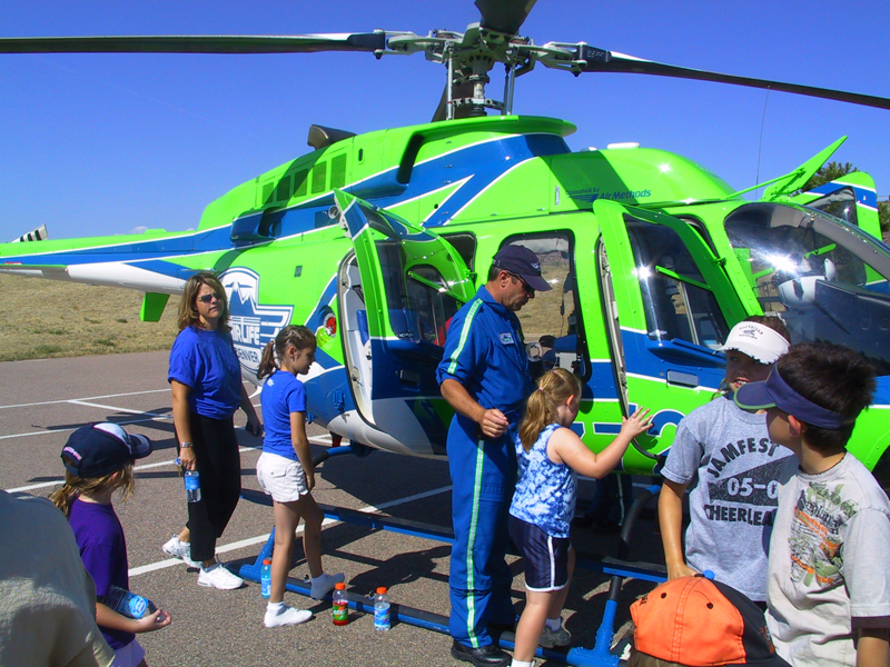 Children being shown around a heli by staff